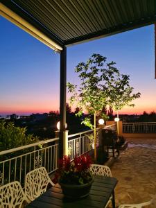 a porch with a table and chairs and a sunset at Eleana Luxury Private Apartment in Neos Marmaras