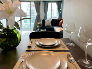- une table à manger avec des assiettes et des verres à vin dans l'établissement Stylish 2BR City View - BTS St.Louis - Ultra Fast Wifi, à Bangkok