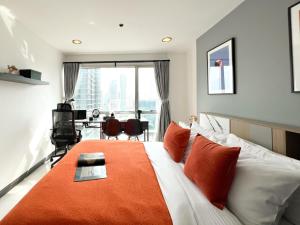 une chambre avec un grand lit avec une couverture orange dans l'établissement Stylish 2BR City View - BTS St.Louis - Ultra Fast Wifi, à Bangkok 37 autres photos
