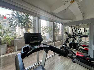 une salle de sport avec trois tapis de course et un ordinateur portable sur un tapis de course dans l'établissement Stylish 2BR City View - BTS St.Louis - Ultra Fast Wifi, à Bangkok