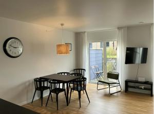 a dining room with a table and chairs and a clock at Spacious Apartment for 7 in Sabro