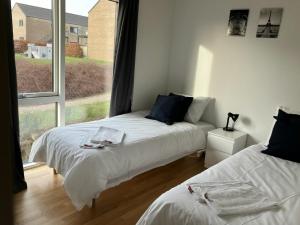 two beds in a room with a large window at Spacious Apartment for 7 in Sabro