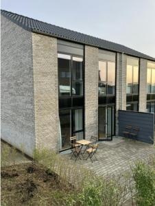 a brick building with a patio with two chairs and a table at Spacious Apartment for 7 in Sabro