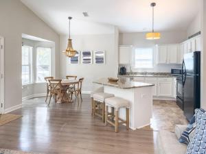 a kitchen with white cabinets and a table and chairs at Seagrove, 2 Bd , Sleeps 8, Stillwater 30A, Walk to Beach ,Pool in Santa Rosa Beach