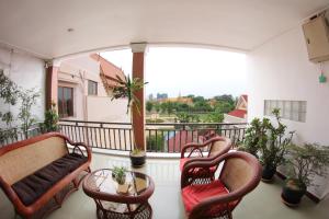 a balcony with chairs and a table and a window at Royal Riverside SkyHotel - Free Laundry in Phnom Penh