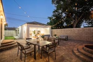 Un patio con una mesa y sillas de madera. en Luxury Hangout - Private Spa - Game Room - Arcade, en Long Beach