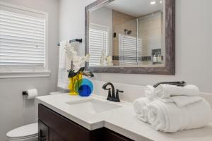 Un baño blanco con lavabo y espejo. en Luxury Hangout - Private Spa - Game Room - Arcade, en Long Beach 30 fotos más