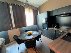 a kitchen with a table and chairs in a room at Appart'Hôtel "Le Phoenix" in Montbéliard