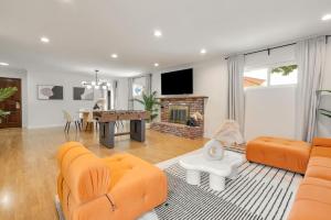a living room with orange furniture and a fireplace at Trendy Getaway - Hot Tub - Putt Putt - Games in Long Beach