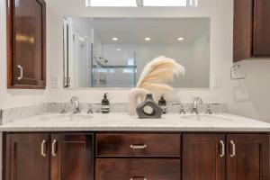 a bathroom with two sinks and a large mirror at Trendy Getaway - Hot Tub - Putt Putt - Games in Long Beach +55 photos