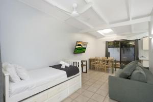 a bedroom with a bed and a couch and a table at Unit 183 Amaroo Spacious Family Unit in Nelly Bay