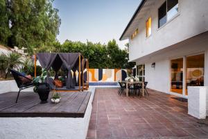 a patio with a table and chairs and a house at 2-Story Sanctuary - Spacious Hot Tub - Billiards in Los Angeles