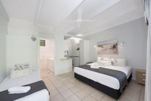 Un dormitorio con dos camas y un baño. en Unit 129 Amaroo Superior Twin Studio Apartment, en Nelly Bay