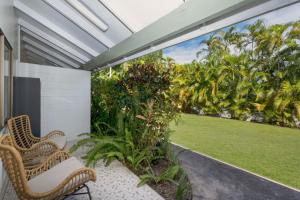 un patio al aire libre con 2 sillas y un jardín en Unit 129 Amaroo Superior Twin Studio Apartment, en Nelly Bay
