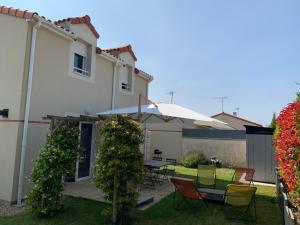 a patio with a table and chairs and an umbrella at Greg House 49 - Chambres d'Hôtes in Beaupréau +24 photos