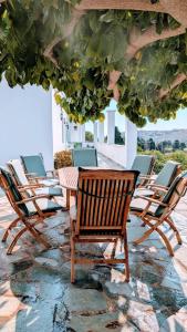 a group of chairs and tables on a patio at Stellinas Pretty House in Andros +27 photos