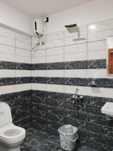 a black and white bathroom with a toilet and a sink at Anantha Guest House in Trivandrum