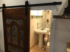 a bathroom with a wooden door and a sink at Main Street Glorious Penthouse in Telluride +19 photos