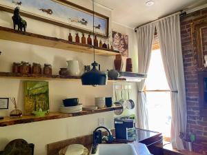 a kitchen with a sink and shelves with pots and pans at Main Street Glorious Penthouse in Telluride