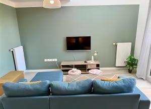 ブシー・サン ・ジョルジュにあるModern Duplex- Disneyland Parisの青いソファとテレビのあるリビングルーム