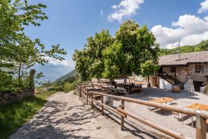 a dirt road next to a house with a fence at Malga San Giovanni in Arco