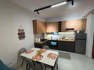 a kitchen with a table with two pizzas on it at Flat in Orikum Beach in Orikum