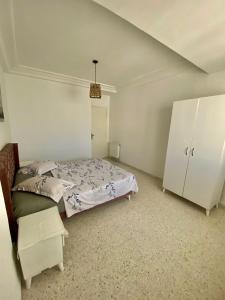 a bedroom with a bed and a white cabinet at emplacement exceptionnel in Tunis