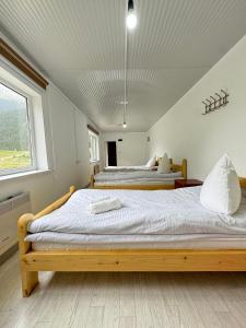 two beds in a room with two windows at Altygat Lodge Barskoon in Barskoon