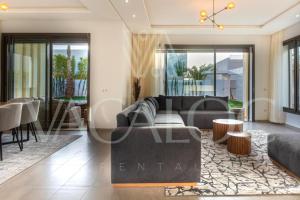 un soggiorno con un divano e un tavolo di Houd Taghazout - luxury villa - Pool - 6 or 7 Px a Taghazout