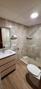 une salle de bain avec toilettes, lavabo et miroir dans l'établissement APARTAMENTO CALLE MENORCA A 100 MT del MAR, à Playa de Gandia