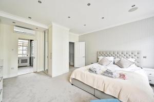 a white bedroom with a large bed and a window at 4 Rooms, 5 Beds, Spacious House in London