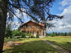 a large wooden house in the middle of a field at Pensiunea Dealu Negru 17B in Dealu Negru