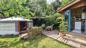 jurta na tarasie obok domu w obiekcie La Yourte du Jardin Caché w mieście Marmande