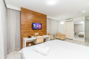 Cette chambre comprend un lit, un bureau et une télévision murale. dans l'établissement Vision Hotel em Brasília 59892, à Brasilia