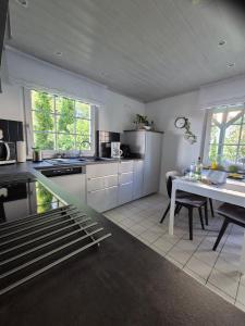 a kitchen with white cabinets and a table in it at Ferienhaus Im Harzvorland in Seesen