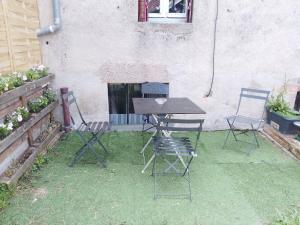 a table and chairs in front of a building at Studio calme avec billard in Saint-Priest