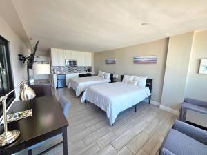 Una habitación de hotel con dos camas y un escritorio. en Oceanfront Studio 2 Queen beds kitchenette & pool, en Daytona Beach 27 fotos más