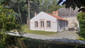 a small white building with windows on the side of it at Gîte du Château des Bretonnières sur Vie in Commequiers