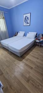 a large bed in a bedroom with a blue wall at Ilia's Coastal Apartement in Vlorë