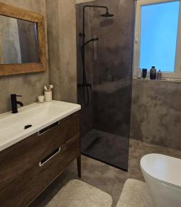 a bathroom with a shower and a sink and a toilet at Ilia's Coastal Apartement in Vlorë