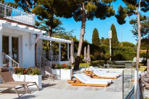 een groep ligstoelen en parasols op een patio bij Nu Aria Taunus Relais in Numana