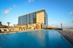 a hotel with a swimming pool in front of a building at Sunrise Oceanfront 2 Full Studio w/kitchen & pool in Daytona Beach