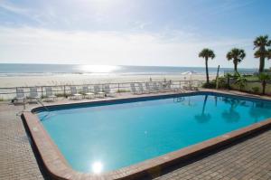a large swimming pool next to the beach at Sunrise Oceanfront 2 Full Studio w/kitchen & pool in Daytona Beach +23 photos