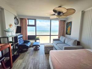 1 dormitorio con 1 cama y sala de estar con vistas al océano en Sunrise Oceanfront 2 Full Studio w/kitchen & pool, en Daytona Beach