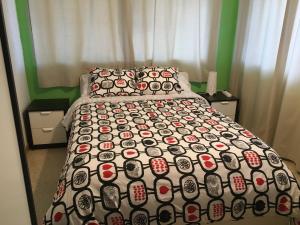 a bedroom with a bed with a comforter on it at Hostal Tres Cantos in Tres Cantos