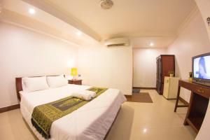 a hotel room with a bed and a television at RS Guesthouse in Phnom Penh