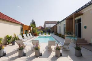 a patio with chairs and a swimming pool at Dripper Urban Retreat in Oradea
