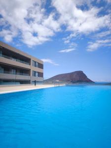 a large pool of blue water in front of a building at La Tejita Amor by BE HAPPY Sotavento Suites New 2025 in El Médano