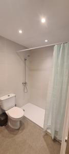 a white bathroom with a toilet and a shower at Antiga Fonda la Palma in Tremp