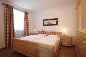 una camera da letto con un letto con lenzuola bianche e una finestra di Ferienwohnungen Kirschner a Bad Birnbach